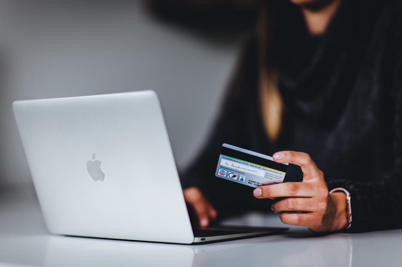 A person holds their credit card while shopping online