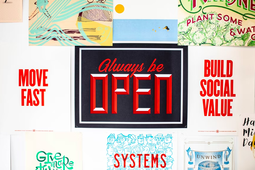 Various typographic prints with slogans like "always be open" and "build social value"