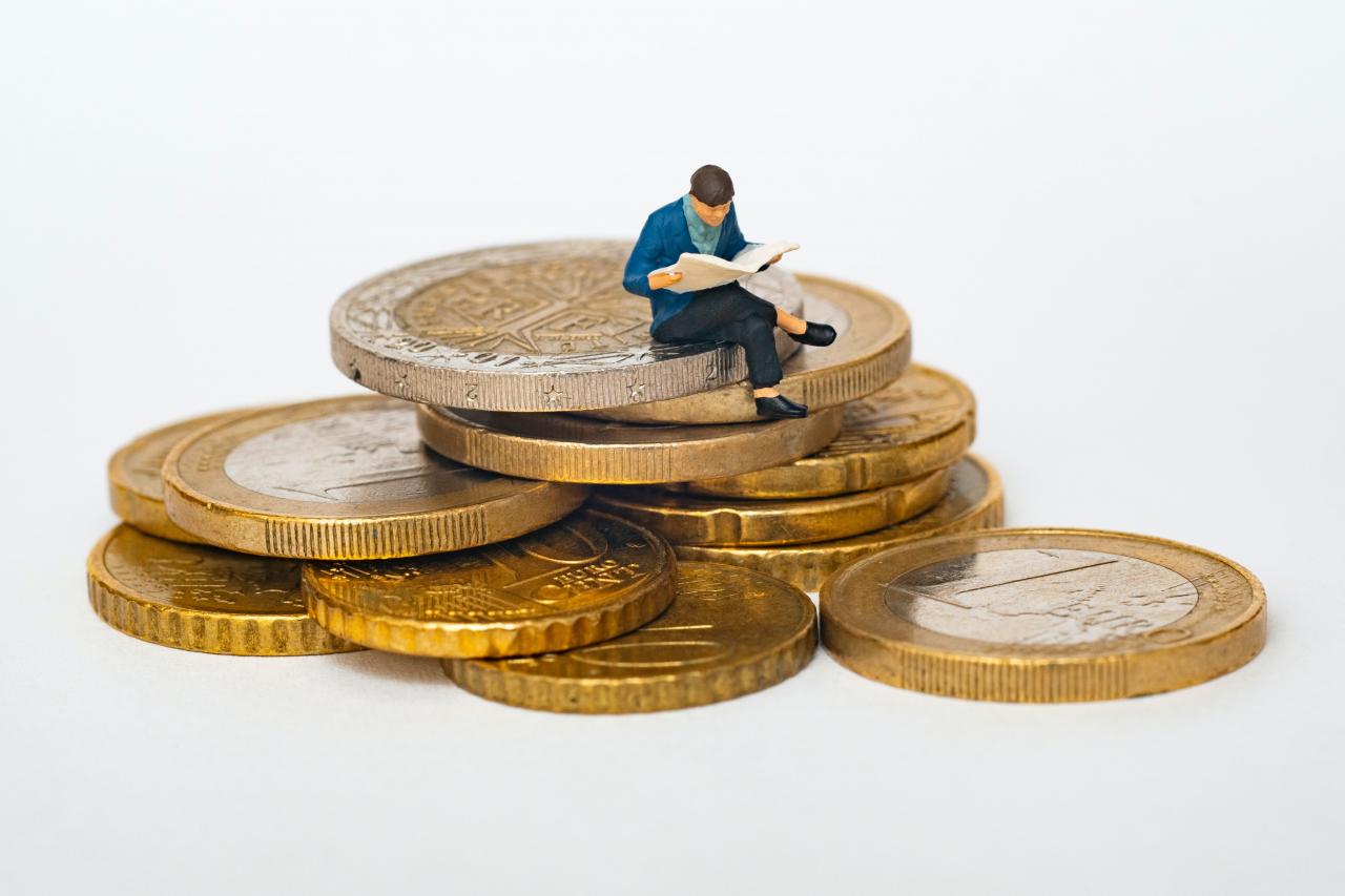 Man sits on coins reading paper - whats the future of ESG investment?