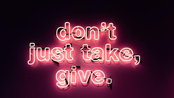 Neon sign reads "dont just take, give"