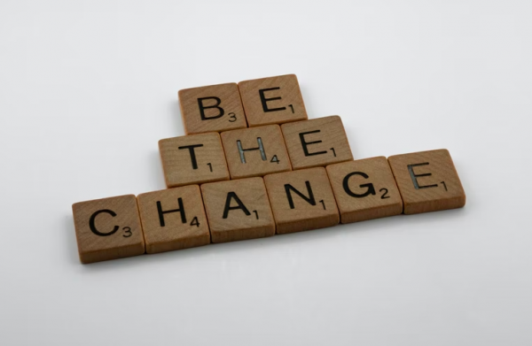 Wooden scrabble tiles spell out the CSR message "Be the change"